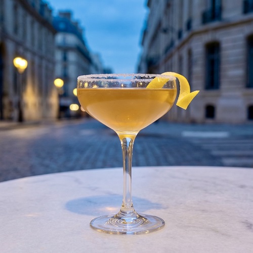 Classic Sidecar cocktail in a sugar-rimmed coupe glass with lemon twist garnish.